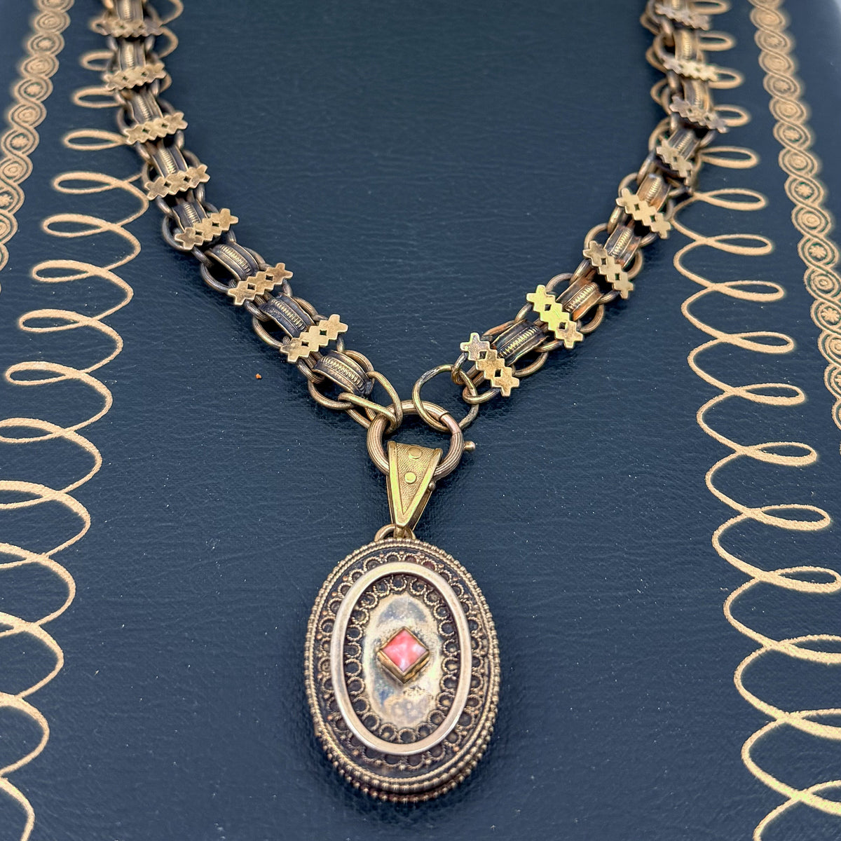 An antique Victorian book chain necklace with a coral locket